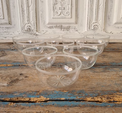 Set on 10 rinsing bowls in clear glass with belt sanding and sanded star at the bottom.